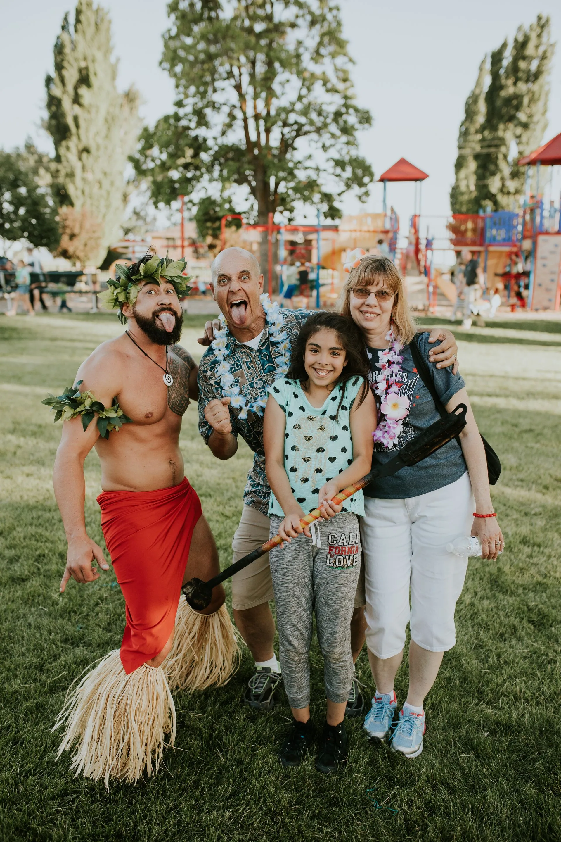 A group of people are posing for a picture in a park.