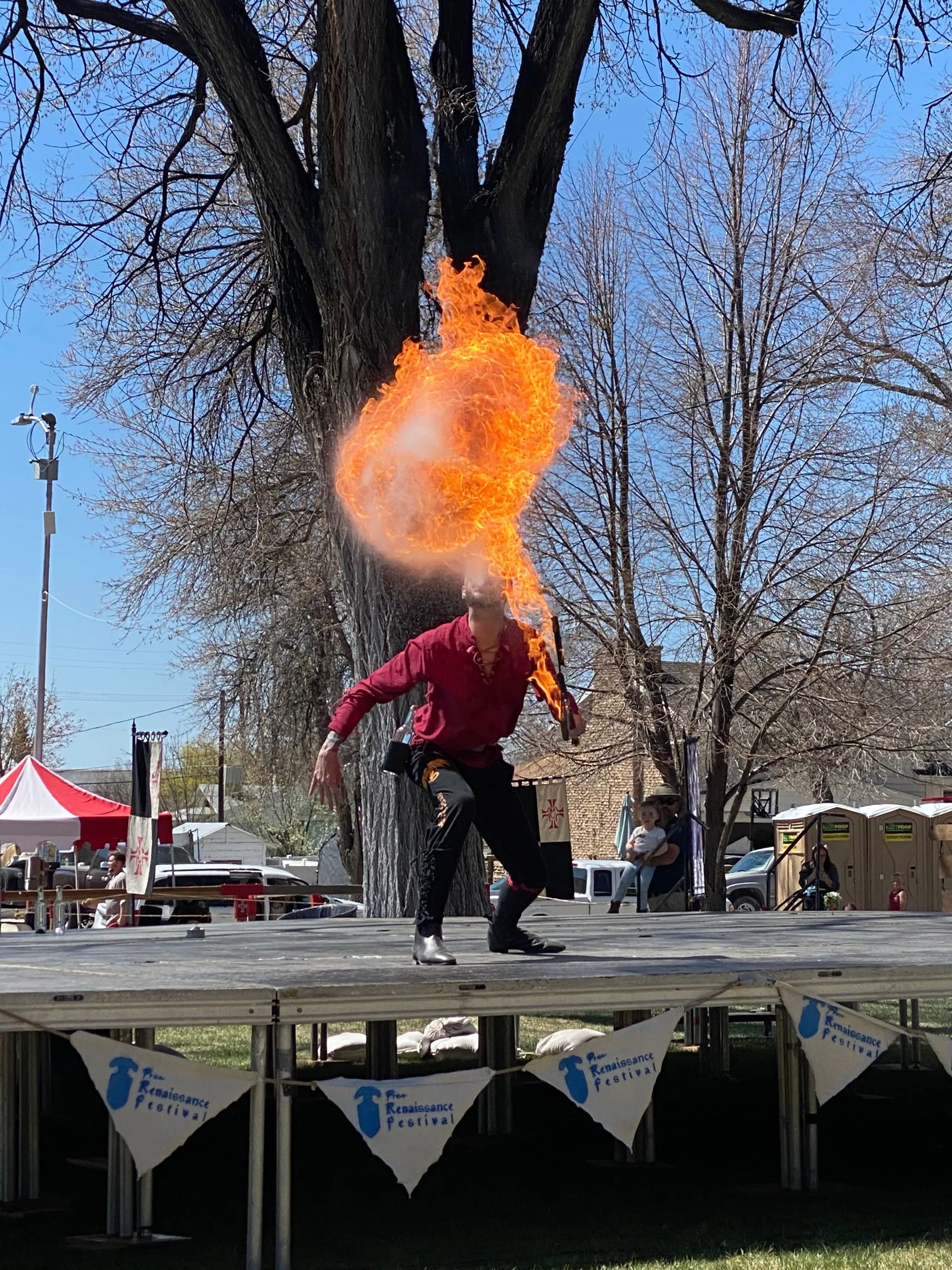 A man is standing on a stage with flames coming out of his mouth.