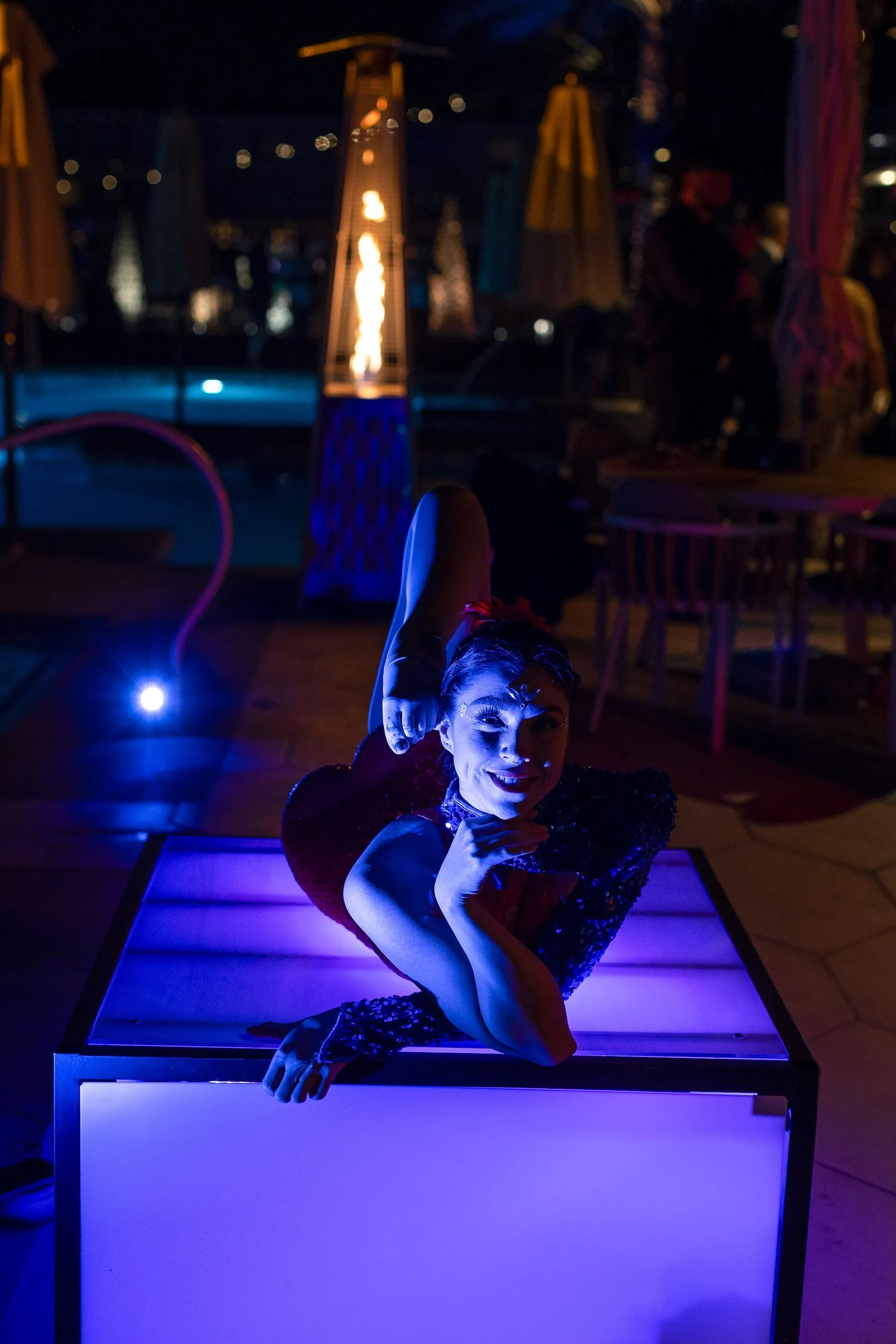 A woman is doing a trick in a box at night.