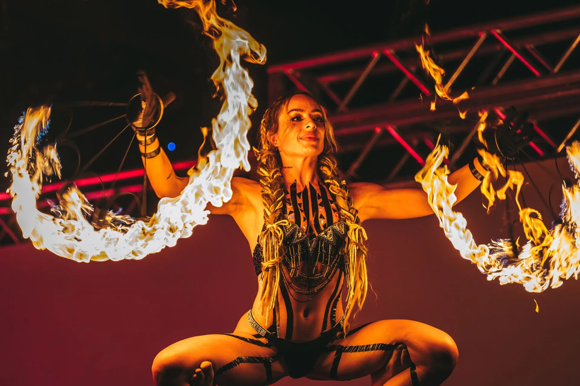 A woman is dancing with fire in her hands.