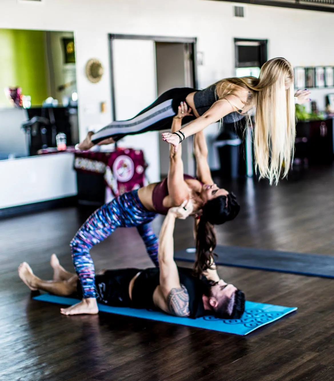A group of people are doing yoga together in a gym.