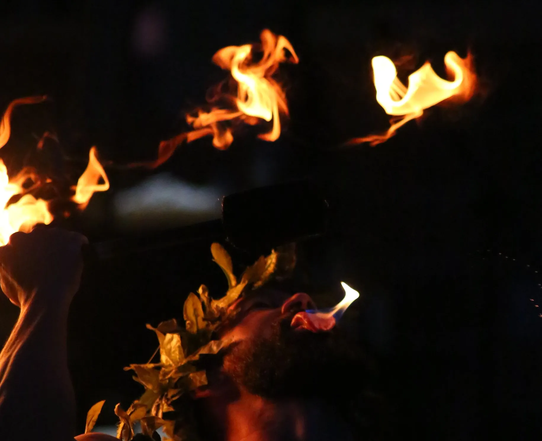 A man is holding a torch with flames coming out of it