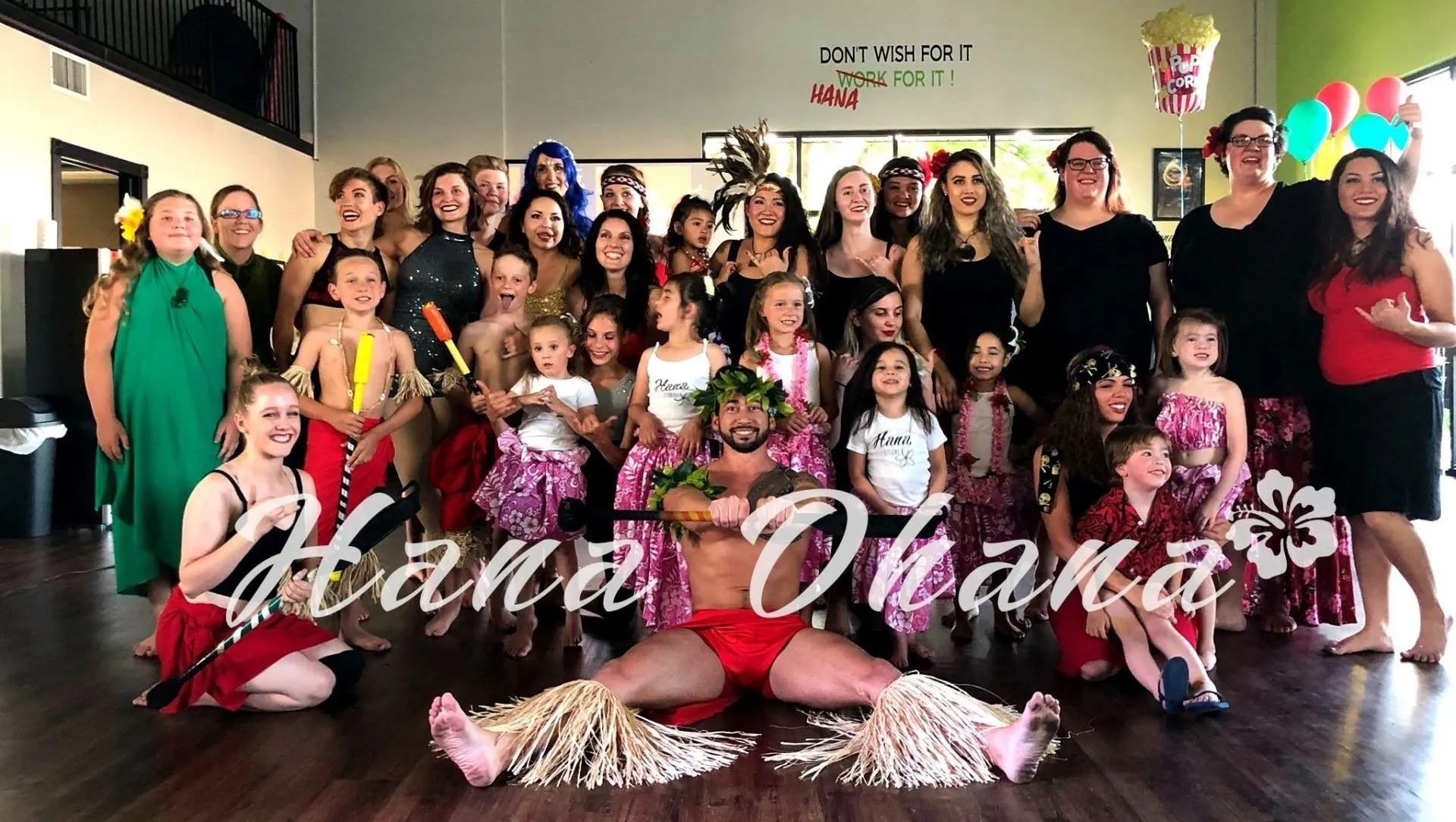 A group of people are posing for a picture in a dance studio.